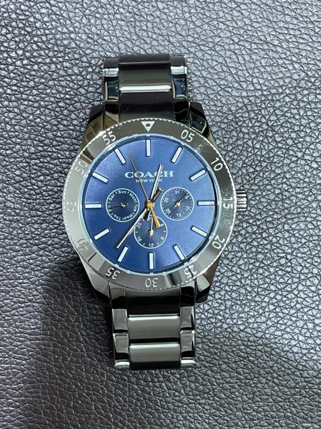 コーチのメンズ腕時計「ケイシーウォッチ42MM」盤面の青はミネラルクリスタルを通してより煌びやかに。