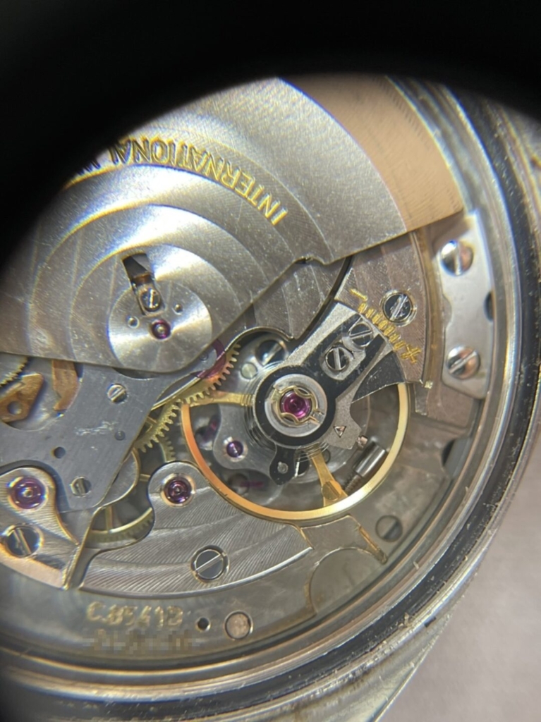 IWC自動巻きの腕時計のテンプを拡大すると何かが挟まっているのがわかります