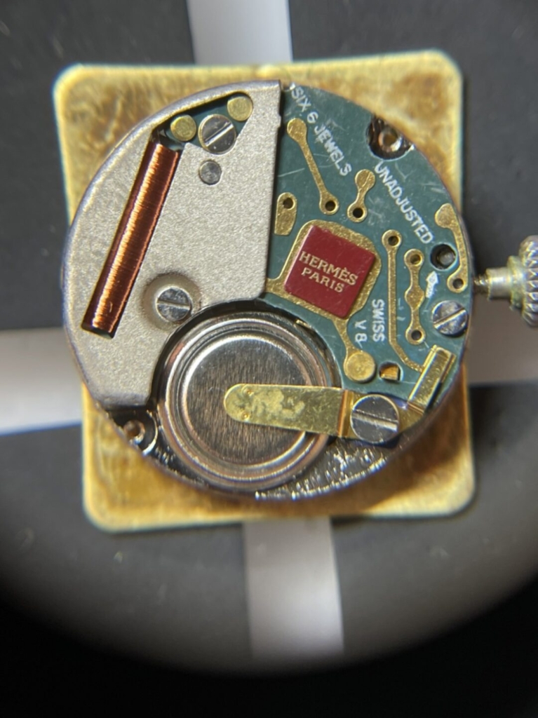 エルメスの時計「カレーシュ」の内部、電池押さえでマイナス極面が留められていた
